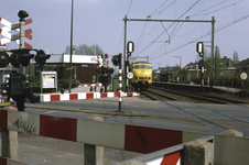 858044 Gezicht op de spoorwegovergang in de Mr. Tripkade te Utrecht, met het N.S.-station Utrecht Overvecht.